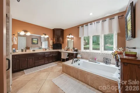 a spacious bathroom with a tub sink and mirror