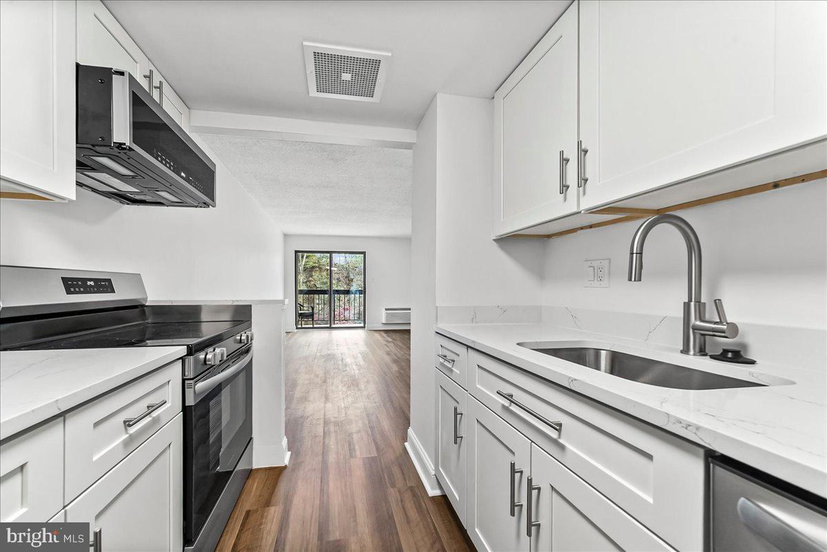 800 Avondale Road, Unit 5Q Wallingford, PA 19086 - Photo 11 of 25 a kitchen with stainless steel appliances granite countertop a sink and stove top oven