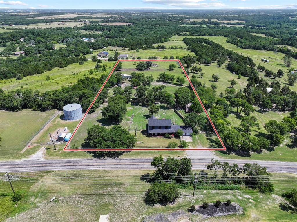 4453 Farm To Market 902 Howe, TX 75459 - Photo 18 of 40 Expansive rural property featuring a large structure with a dark roof, surrounded by mature trees and verdant fields