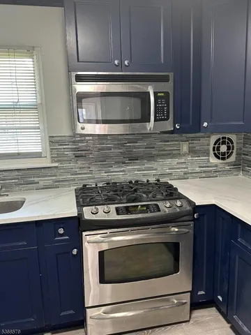 a kitchen with granite countertop a stove and a sink