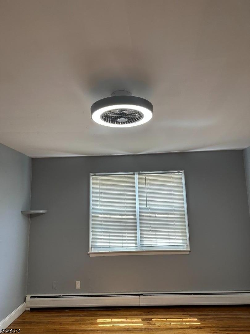 12A Gramercy Gardens Place, Unit 12 Middlesex, NJ 08846 - Photo 3 of 7 an empty room with wooden floor and windows