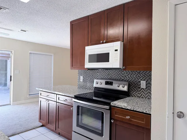 a kitchen with granite countertop stainless steel appliances and wooden cabinets
