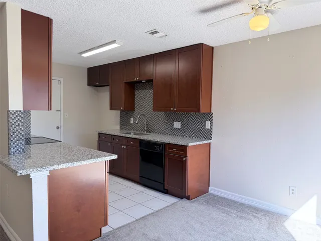 a kitchen with stainless steel appliances granite countertop a sink and a stove