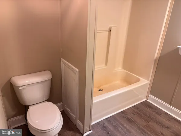 a white toilet sitting next to a bath tub