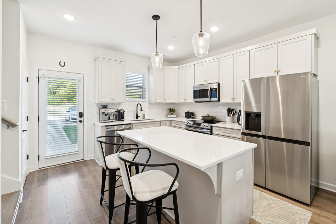 152 Bess Boulevard Spring Hill, TN 37174 - Photo 7 of 25 a kitchen with stainless steel appliances a refrigerator stove microwave and white cabinets