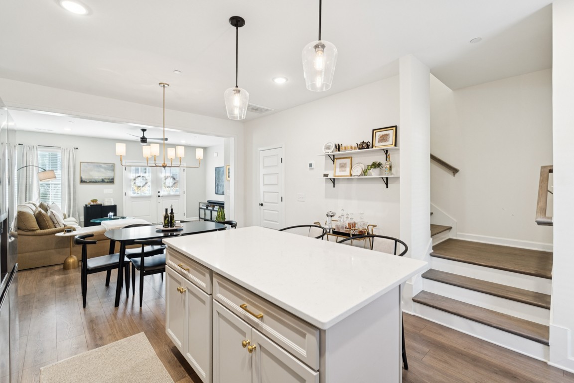 152 Bess Boulevard Spring Hill, TN 37174 - Photo 9 of 25 a kitchen with a stove a refrigerator and a dining table with wooden floor