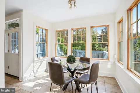 a dining room with furniture large windows and wooden floor