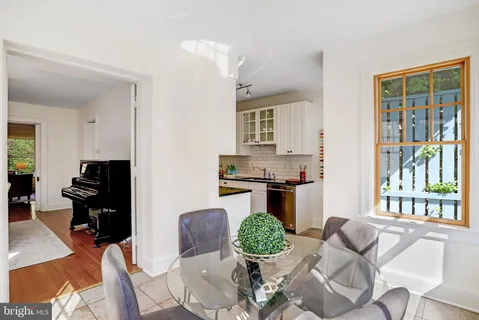 a living room with furniture kitchen view and large windows
