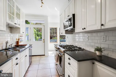 a kitchen with granite countertop a sink stove and cabinets