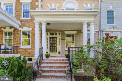 front view of a house with a potted plant and windows