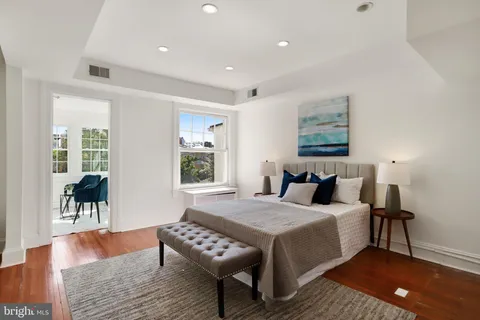 a bedroom with a bed and a table with wooden floor