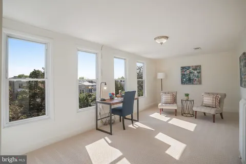 a living room with furniture a lamp and a potted plant