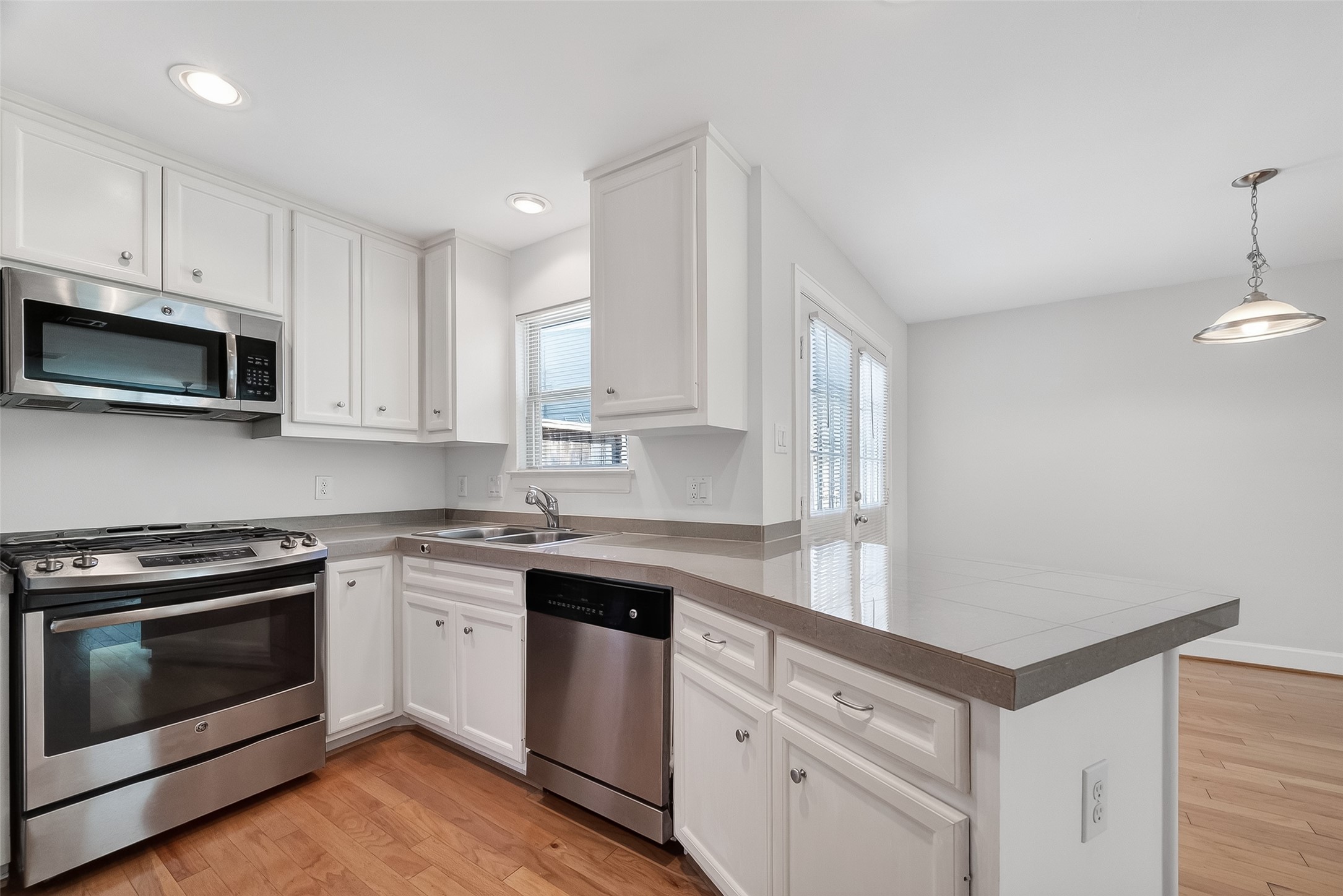 5951 S Loop East, Unit 47 Houston, TX 77033 - Photo 13 of 37 Bright and modern kitchen with sleek stainless steel appliances, white cabinetry, and a spacious countertop. The open layout connects to a dining area with plenty of natural light.