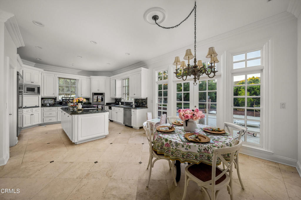 6885 Coyote Canyon Road Somis, CA 93066 - Photo 9 of 35 a kitchen island with stainless steel appliances a dining table chairs stove and white cabinets