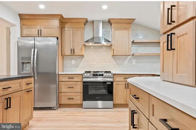a kitchen with stainless steel appliances granite countertop a stove and a refrigerator