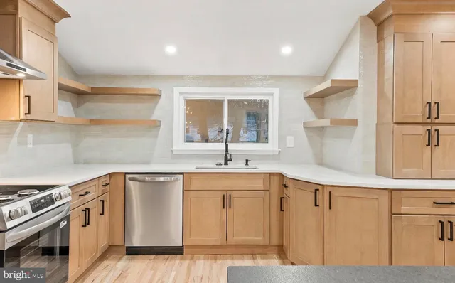 a kitchen with white cabinets and sink