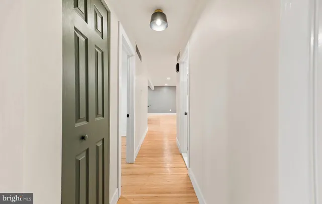 a view of a hallway with wooden floor and staircase