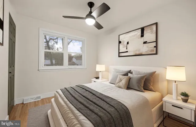 a bedroom with bed and wall painting with wooden floor