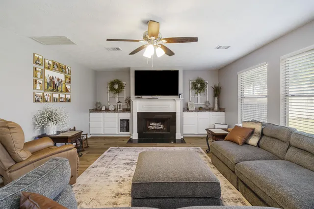 a living room with furniture a flat screen tv and a fireplace