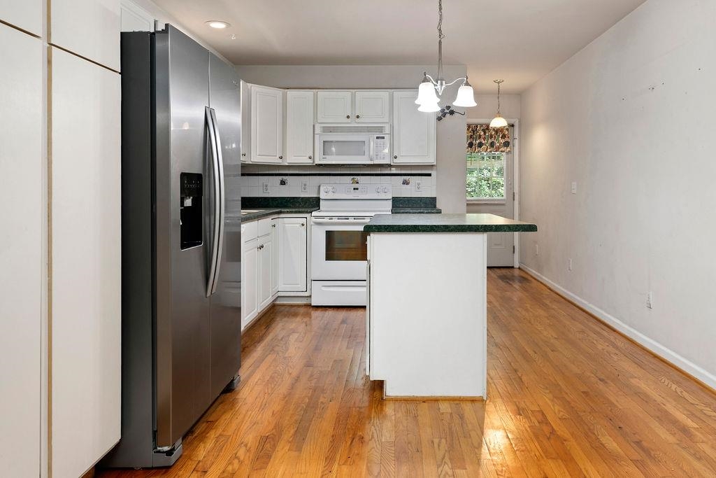 661 Jefferson Drive Palmyra, VA 22963 - Photo 18 of 41 a kitchen with kitchen island white cabinets a sink a window and stainless steel appliances