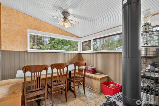 a view of a dining room with furniture a chandelier and large windows