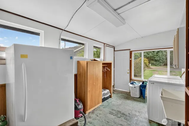 a view of a refrigerator in kitchen and a window