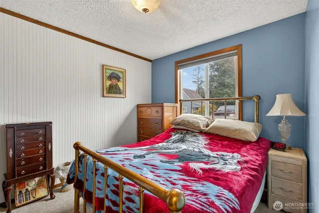 a bedroom with a bed a dresser next to a window