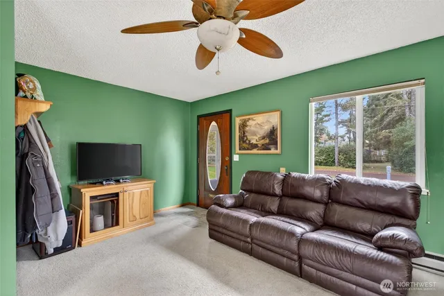 a living room with furniture a flat screen tv and a large window