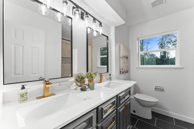 a spacious bedroom with a bed chandelier and a window