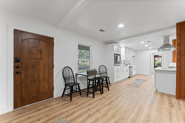 a large white kitchen with stainless steel appliances