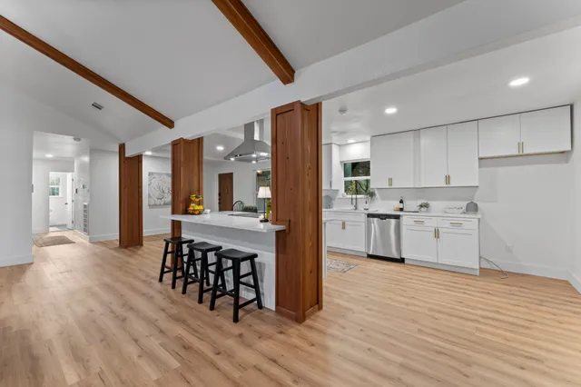 a kitchen with stainless steel appliances kitchen island a dining table and chairs