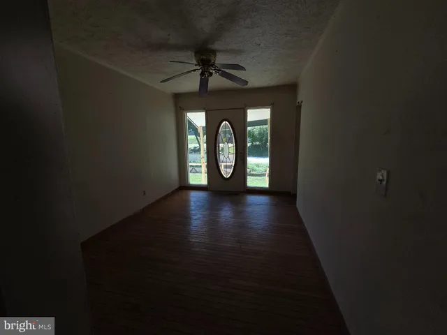 a view of a hallway with wooden floor and windows