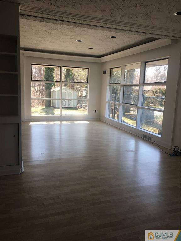 100 Dover Road Colonia, NJ 07067 - Photo 6 of 25 a view of an empty room with wooden floor and a window
