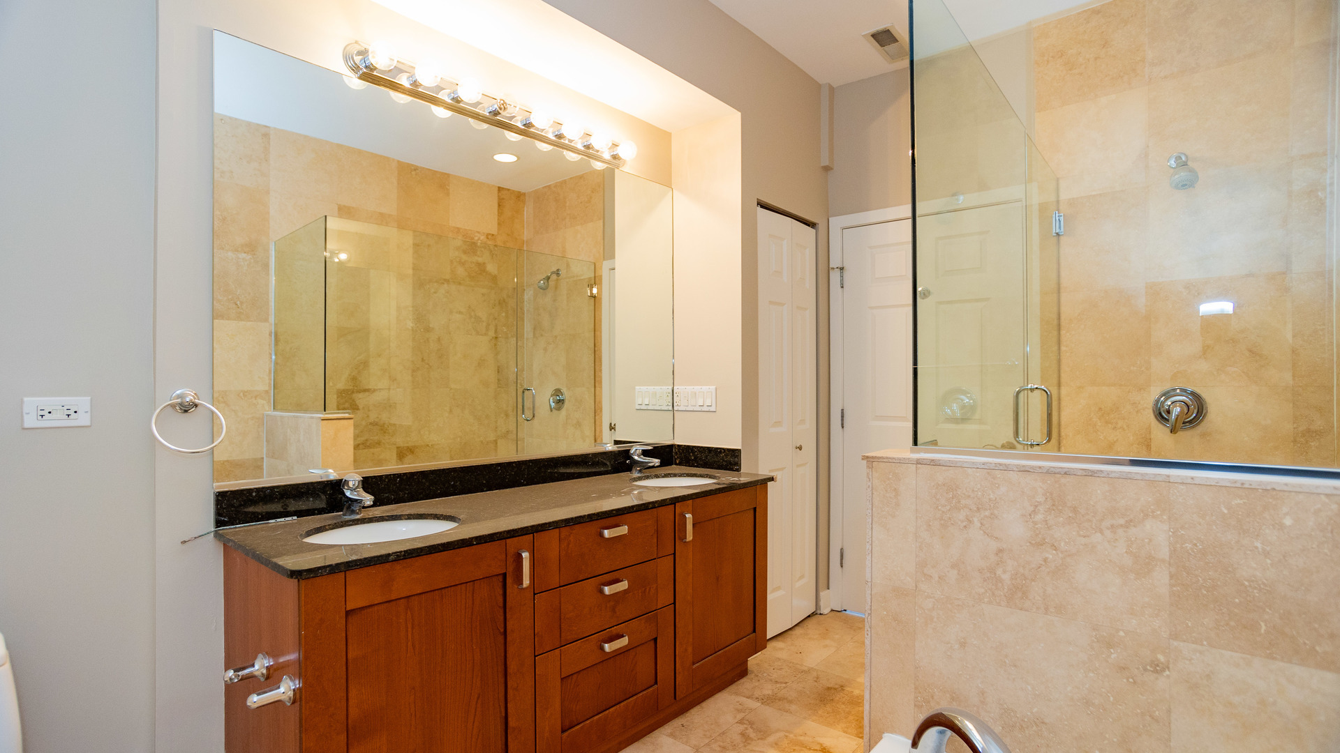Undisclosed Address Chicago, IL 60645 - Photo 15 of 18 a bathroom with a granite countertop sink a mirror and a shower