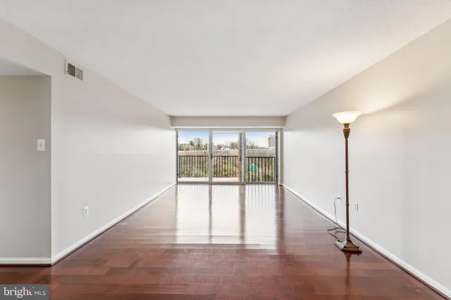 a view of a livingroom with a chandelier fan wooden floor and chandelier