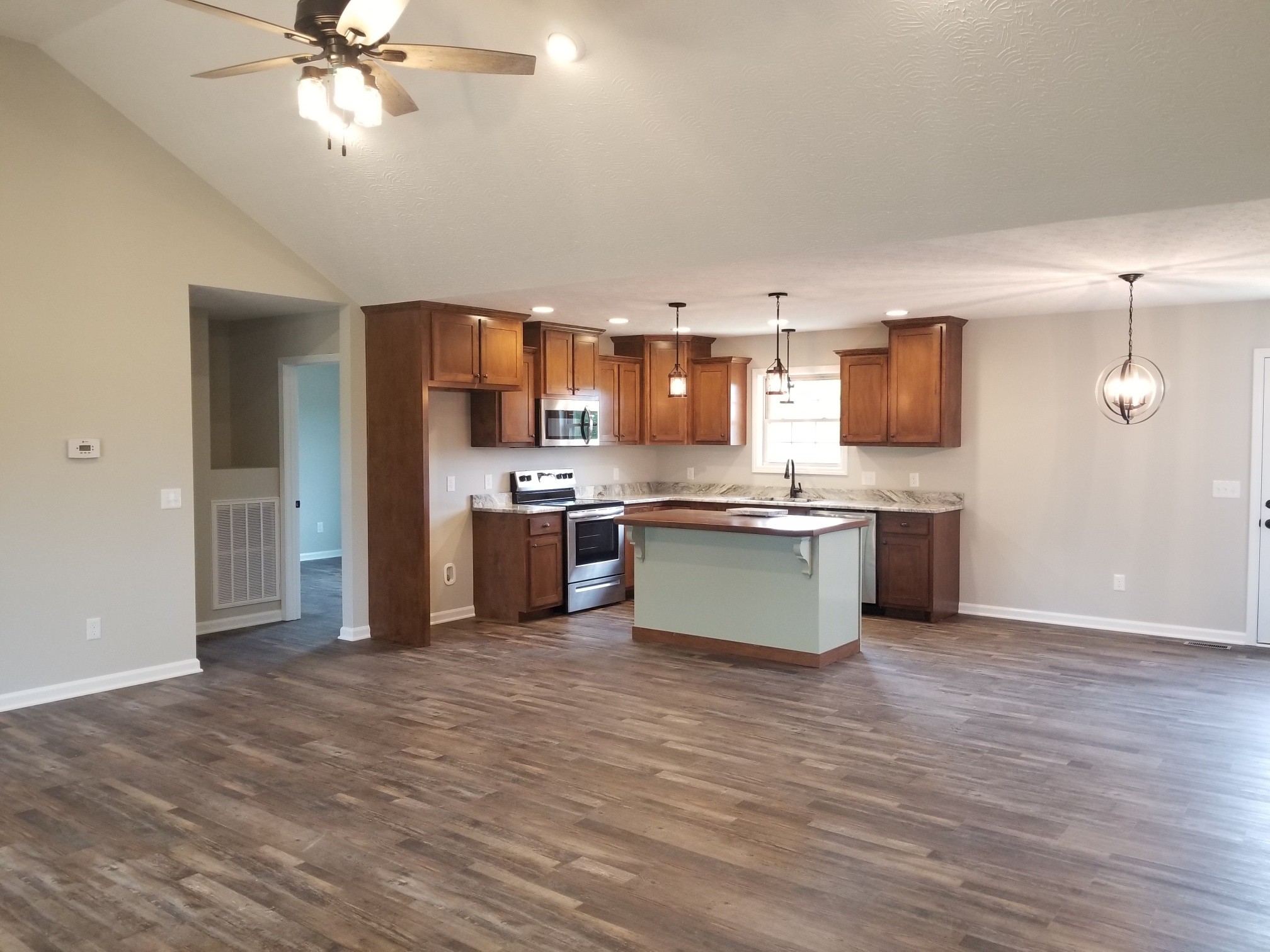2145 Austin Road Lafayette, TN 37083 - Photo 6 of 21 a large kitchen with stainless steel appliances kitchen island granite countertop a stove top oven a sink and a refrigerator