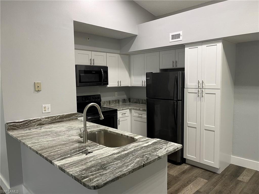 a kitchen with granite countertop a refrigerator and a sink