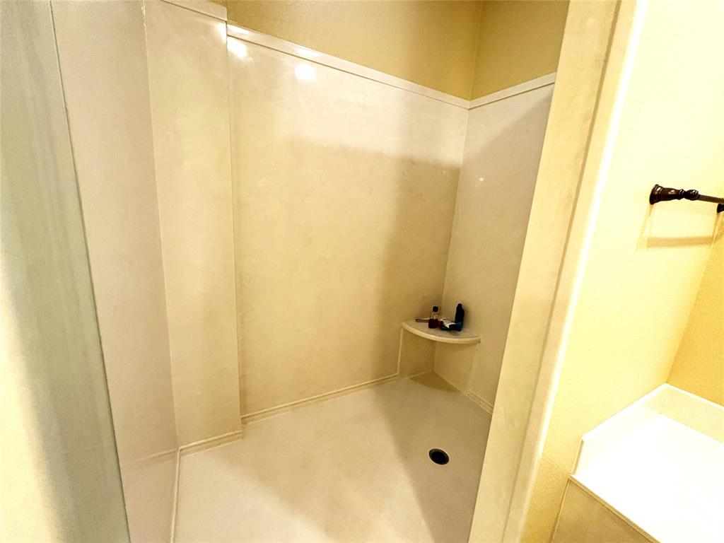 1170 Brazos Loop Gholson, TX 76705 - Photo 24 of 37 Enclosed shower stall with a corner shelf, white paneling, and a dark drain