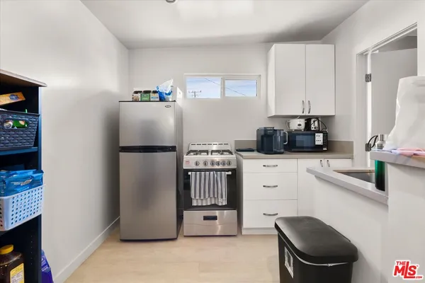 a kitchen with stainless steel appliances a refrigerator sink and white cabinets