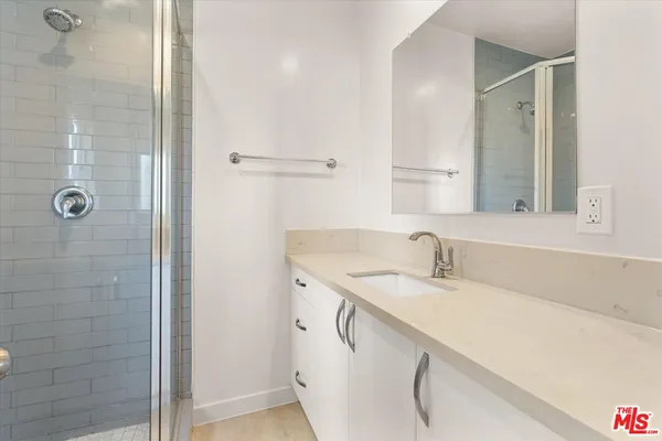 a bathroom with a granite countertop sink a shower and a mirror