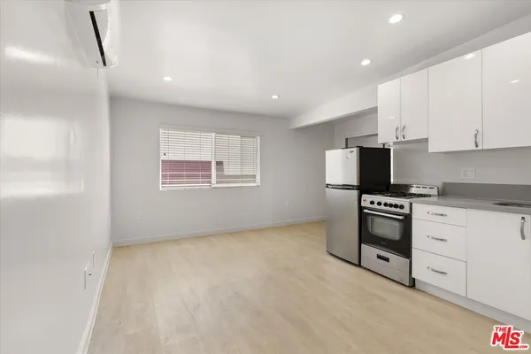 a kitchen with stainless steel appliances white cabinets and a refrigerator