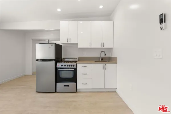 a kitchen with stainless steel appliances white cabinets and a refrigerator