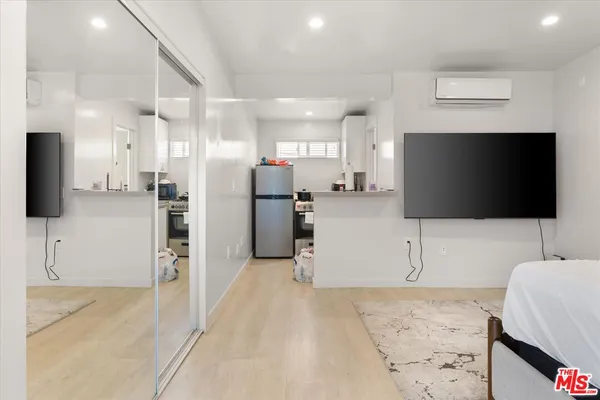 a living room with stainless steel appliances furniture and a flat screen tv