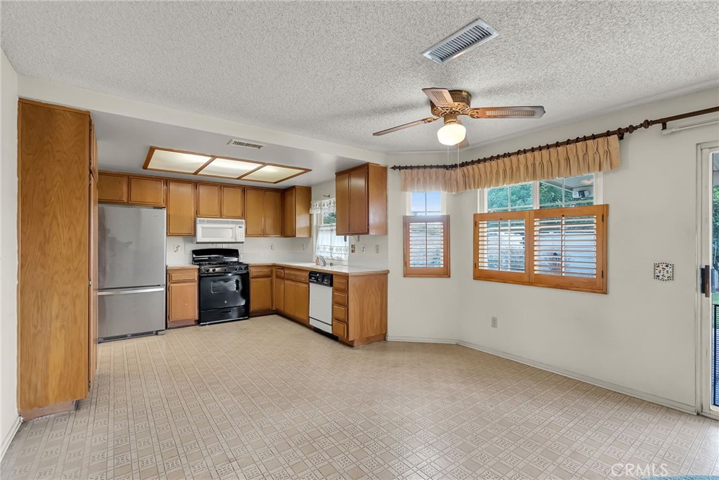 2892 Jackson Street Riverside, CA 92503 - Photo 8 of 29 a kitchen with stainless steel appliances a refrigerator a sink a stove a microwave a center island and furniture