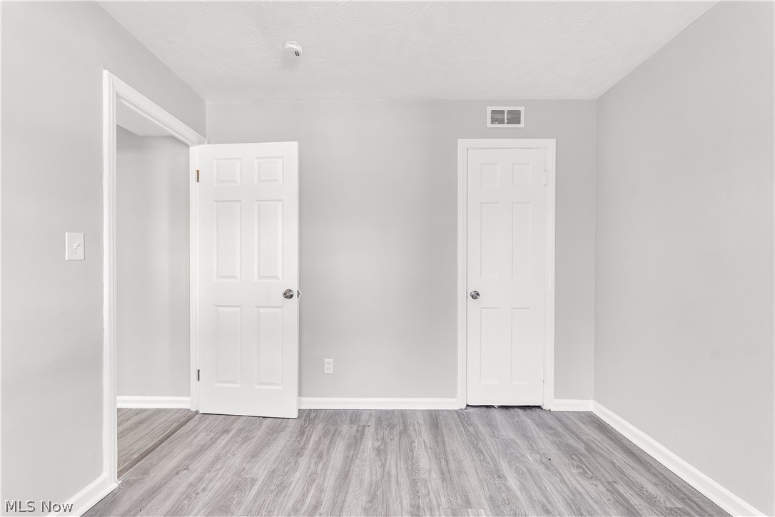 2521 Greenvale Road Cleveland, OH 44121 - Photo 18 of 23 Room featuring wood-finish flooring, light gray wall paint, and white baseboards