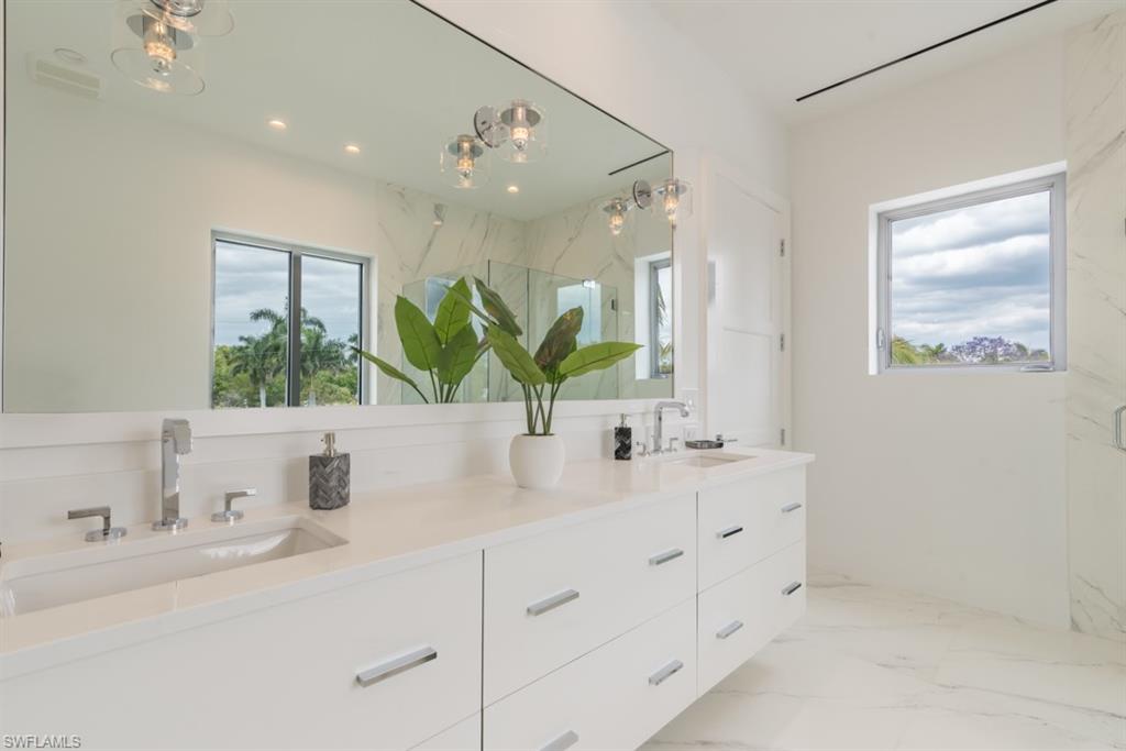 325 Banyan Boulevard Naples, FL 34102 - Photo 11 of 19 a bathroom with a double vanity sink mirror and next to a window