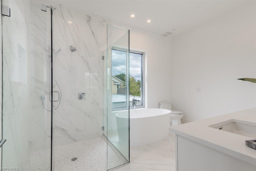 325 Banyan Boulevard Naples, FL 34102 - Photo 12 of 19 a bathroom with a bathtub and a shower