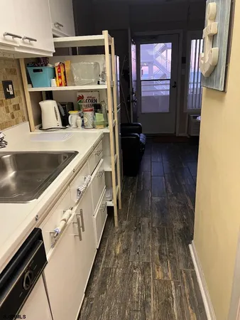 a kitchen with stainless steel appliances granite countertop a sink and wooden floors