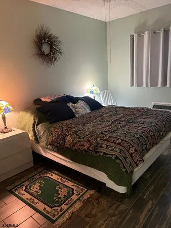a bedroom with a bed rug and wooden floor