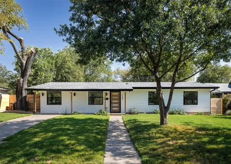 a front view of a house with a garden and yard